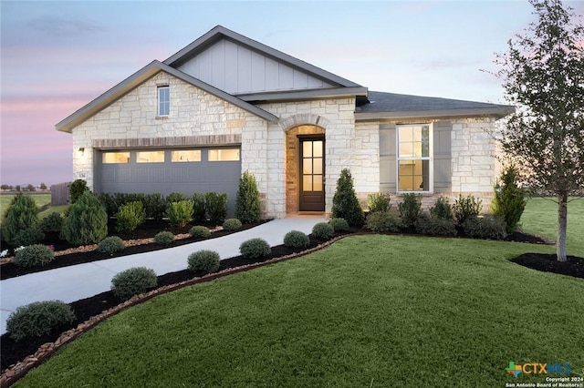 view of front of house featuring a garage and a lawn