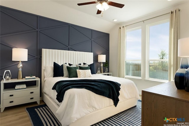 bedroom featuring hardwood / wood-style flooring, ceiling fan, and lofted ceiling