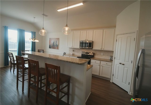 6108 Worthing Dr, Temple, TX 76502 - kitchen with appliances with stainless steel finishes, a kitchen island, tasteful backsplash, dark wood finished floors, and white cabinets