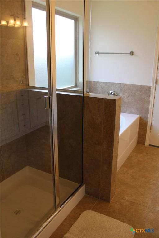 bathroom with tile patterned floors, a stall shower, and a bath