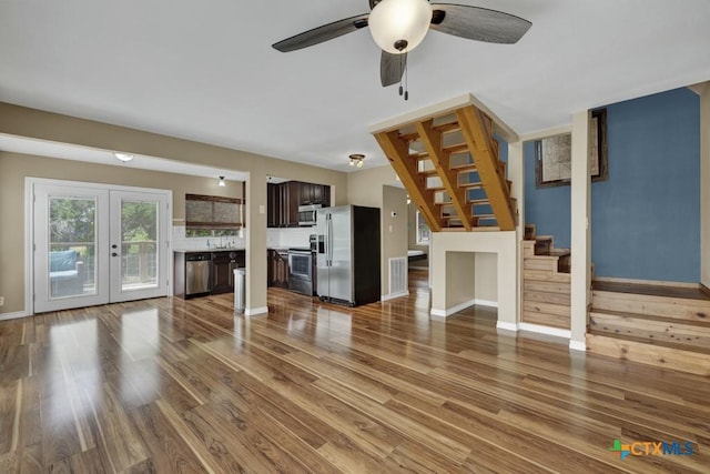 1568 Blueridge Dr, Canyon Lake, TX 78133 - unfurnished living room with stairway, wood finished floors, a ceiling fan, and french doors