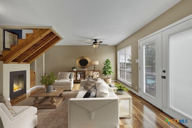1568 Blueridge Dr, Canyon Lake, TX 78133 - living area with wood finished floors, ceiling fan, stairway, and a lit fireplace