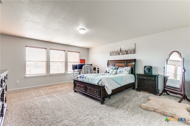 bedroom with light colored carpet and a textured ceiling