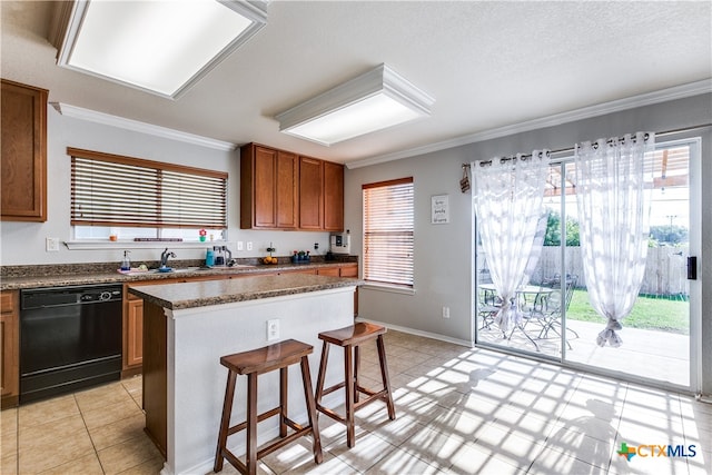 kitchen with dishwasher, plenty of natural light, a kitchen island, and a breakfast bar