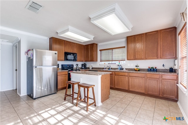 kitchen with crown molding, a kitchen island, a breakfast bar, and stainless steel fridge