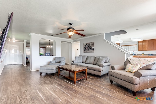 living room with ornamental molding, a textured ceiling, hardwood / wood-style flooring, and ceiling fan