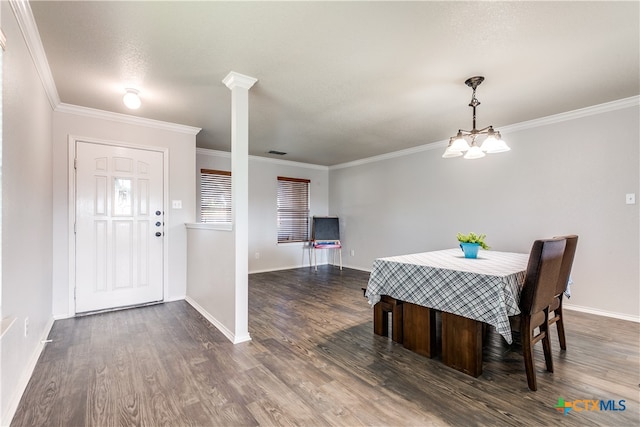 dining area featuring ornamental molding, a textured ceiling, ornate columns, dark hardwood / wood-style flooring, and an inviting chandelier