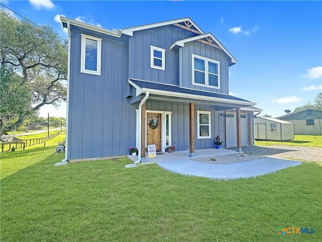 701 S Hudson St, Flatonia, TX 78941 - view of front facade with board and batten siding, a front yard, and covered porch