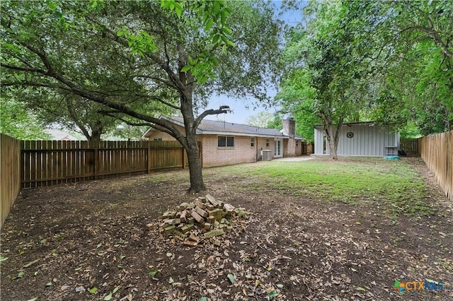 view of yard featuring central air condition unit, an outdoor structure, and a fenced backyard