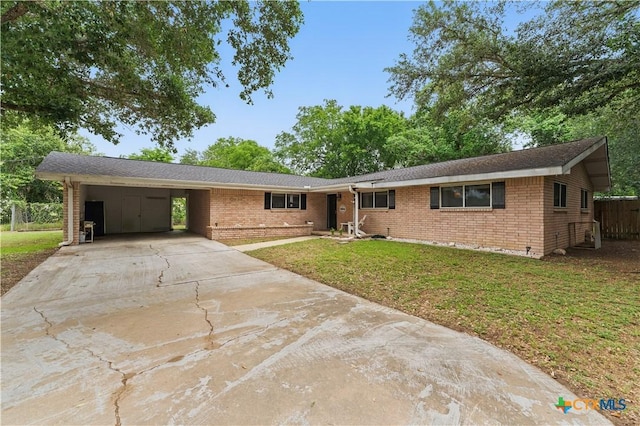 ranch-style house with a carport, a front yard, driveway, and brick siding