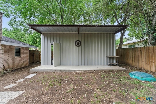 view of outbuilding with a fenced backyard and an outdoor structure