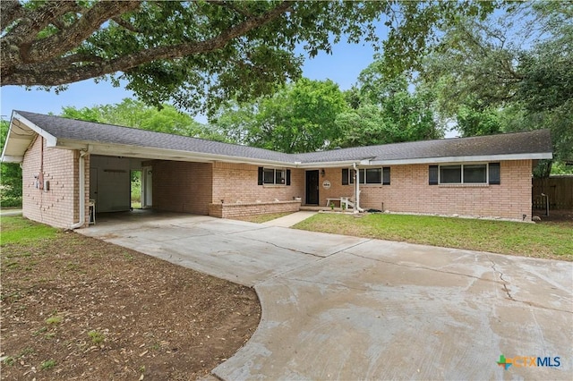 ranch-style house with brick siding, a front lawn, driveway, and an attached carport