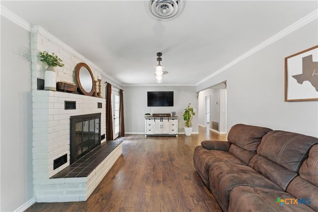 living room featuring visible vents, a brick fireplace, wood finished floors, baseboards, and ornamental molding