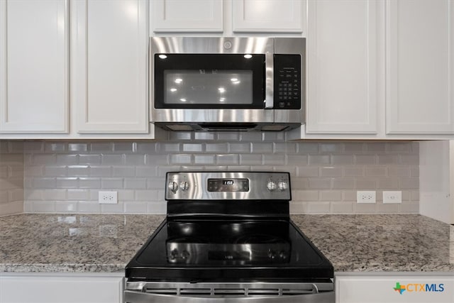 kitchen with tasteful backsplash, appliances with stainless steel finishes, and white cabinets