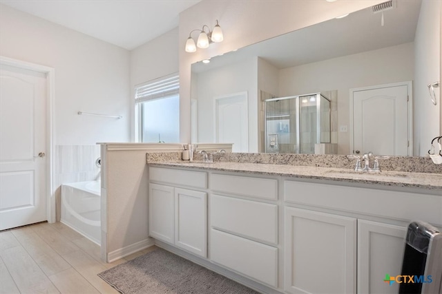 bathroom with vanity, hardwood / wood-style flooring, and separate shower and tub