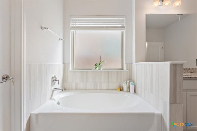 bathroom featuring a washtub and vanity