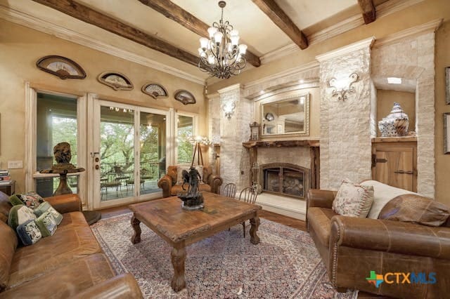 sitting room featuring a chandelier, hardwood / wood-style floors, ornamental molding, and beam ceiling