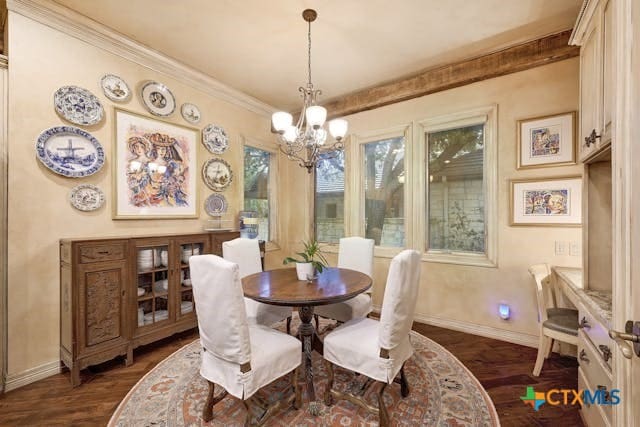 dining space featuring ornamental molding, an inviting chandelier, and dark hardwood / wood-style floors