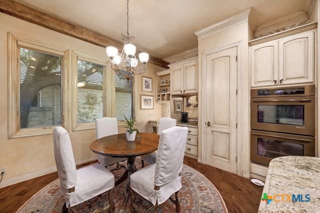 dining room with ornamental molding, an inviting chandelier, and dark hardwood / wood-style floors