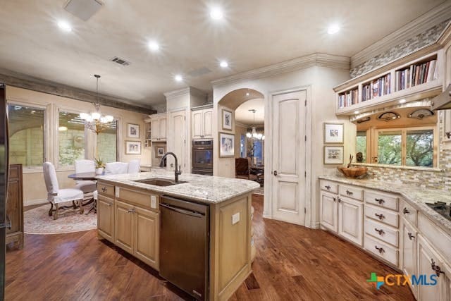 kitchen with stainless steel appliances, sink, an island with sink, dark wood-type flooring, and pendant lighting