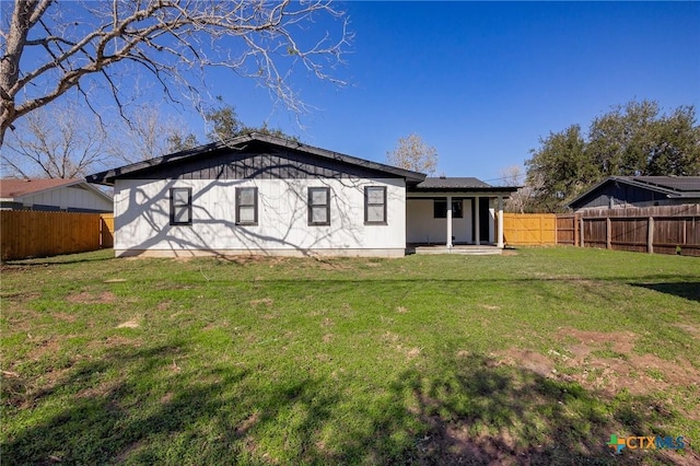 rear view of property featuring a lawn