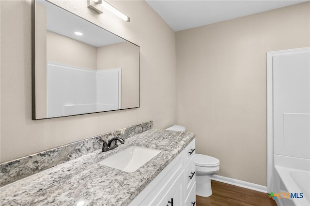 full bathroom featuring hardwood / wood-style flooring, vanity, toilet, and tub / shower combination