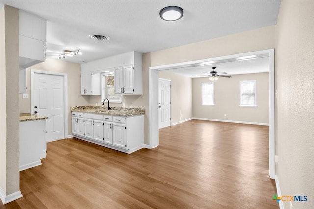 kitchen with sink, light hardwood / wood-style flooring, white cabinets, and ceiling fan