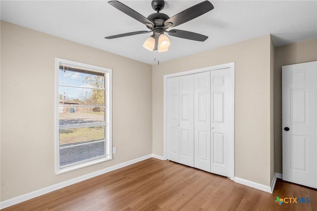 unfurnished bedroom with light hardwood / wood-style flooring, a closet, and ceiling fan