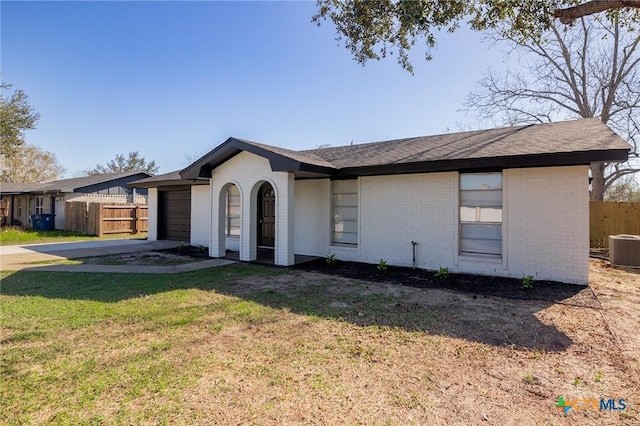 single story home featuring a garage, a front yard, and central air condition unit