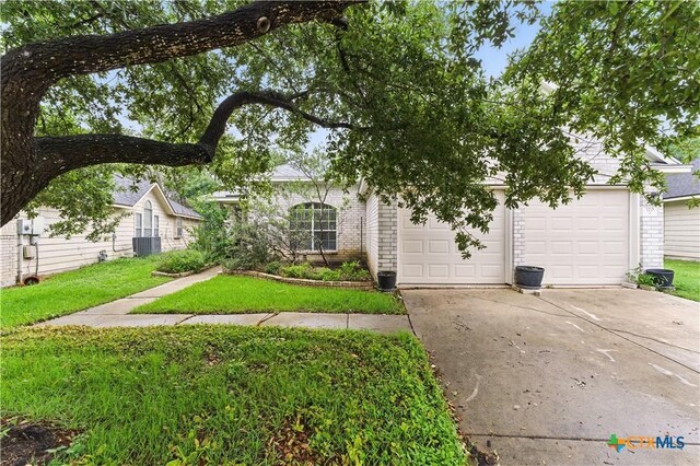 view of front of property with concrete driveway, brick siding, an attached garage, and a front yard