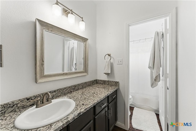 full bath with vanity, toilet, and curtained shower