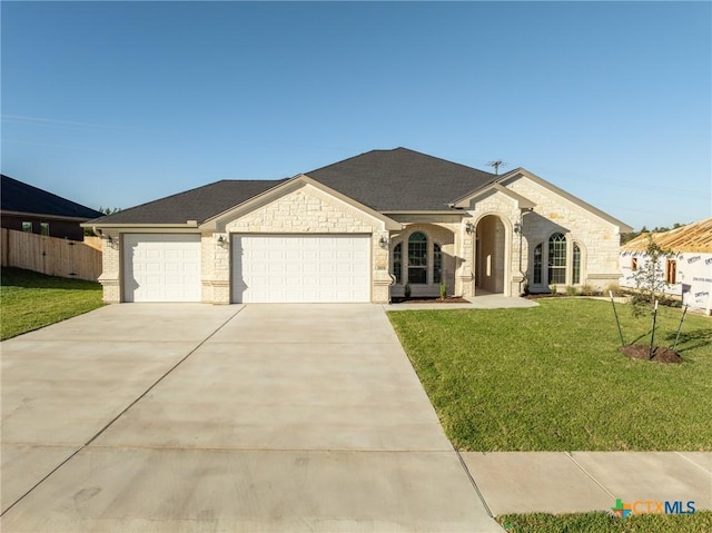 ranch-style house featuring a garage and a front yard