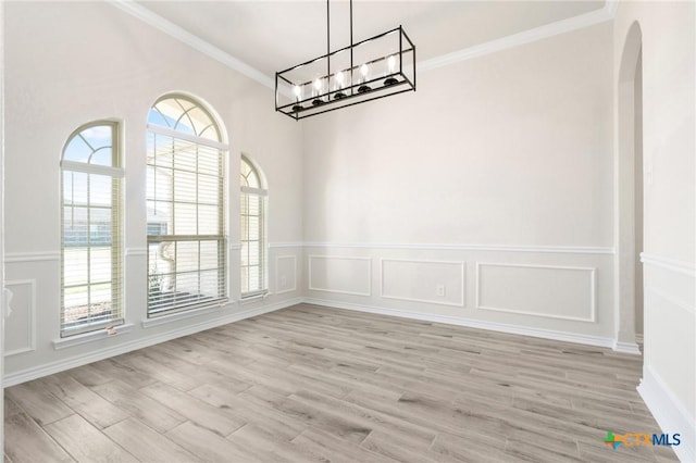 unfurnished dining area featuring ornamental molding, an inviting chandelier, and light hardwood / wood-style floors