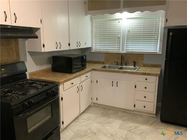 1705 E Poplar Ave, Victoria, TX 77901 - kitchen featuring black appliances, a sink, under cabinet range hood, white cabinetry, and light marble finish floors