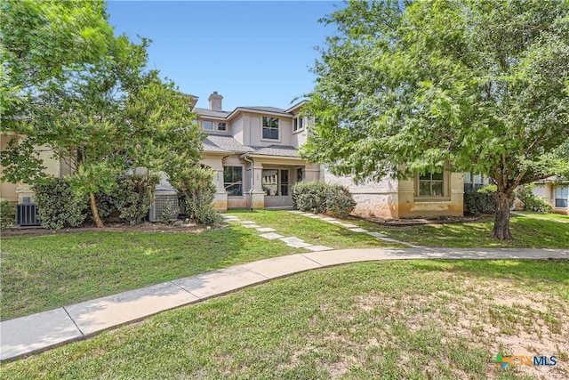 462 Stagecoach Trl, San Marcos, TX 78666 - obstructed view of property featuring stucco siding, a front lawn, and central AC unit