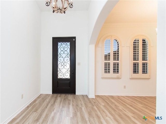 entrance foyer featuring an inviting chandelier, wood finished floors, baseboards, and a healthy amount of sunlight