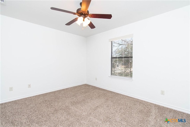 empty room featuring baseboards, ceiling fan, and carpet flooring