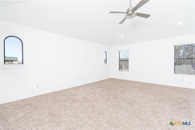 carpeted spare room featuring recessed lighting, baseboards, and lofted ceiling