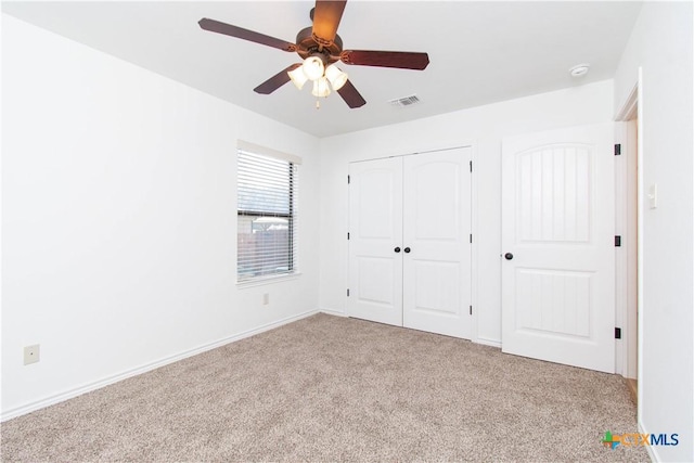 unfurnished bedroom with visible vents, baseboards, ceiling fan, carpet flooring, and a closet