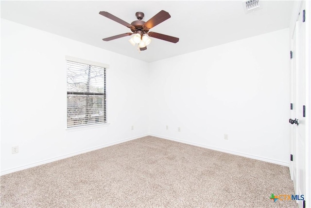 carpeted empty room with visible vents, baseboards, and ceiling fan