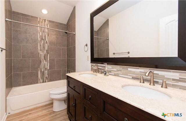 bathroom with a sink, toilet, wood finished floors, and washtub / shower combination