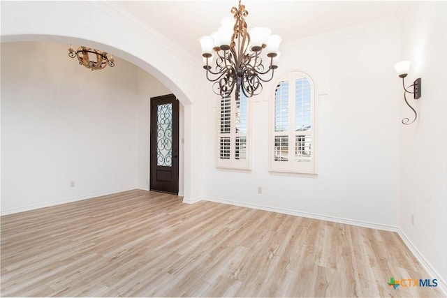 foyer with baseboards, crown molding, and light wood-style floors