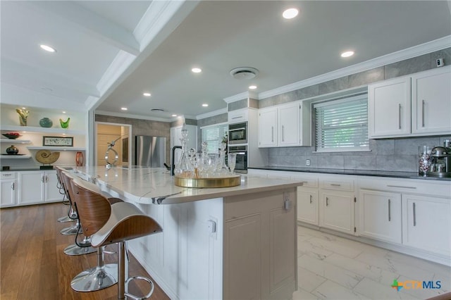 522 Woodland Point Rd, Belton, TX 76513 - kitchen featuring ornamental molding, white cabinetry, appliances with stainless steel finishes, and a breakfast bar area