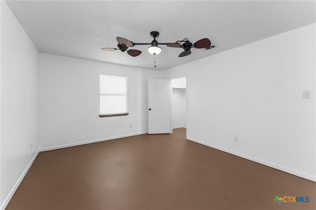 empty room featuring concrete flooring, ceiling fan, and a textured ceiling