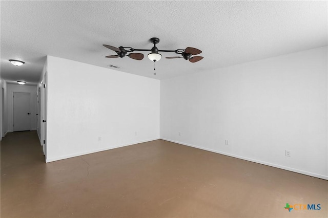 empty room with concrete flooring, ceiling fan, and a textured ceiling