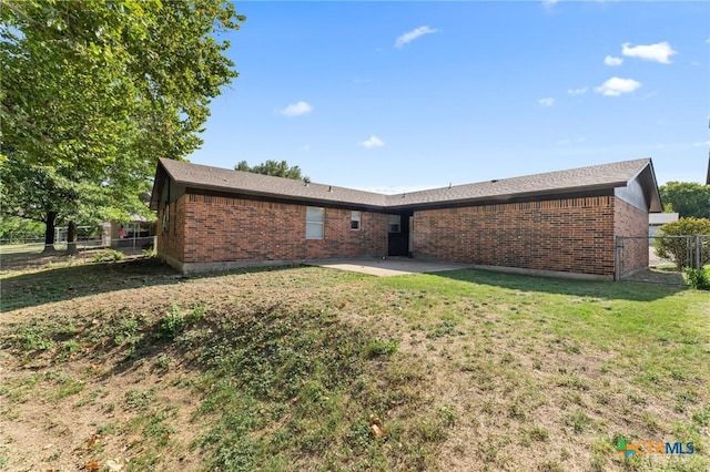 rear view of property featuring a patio and a lawn