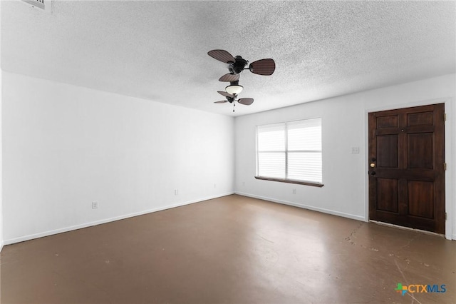 unfurnished room with ceiling fan and a textured ceiling