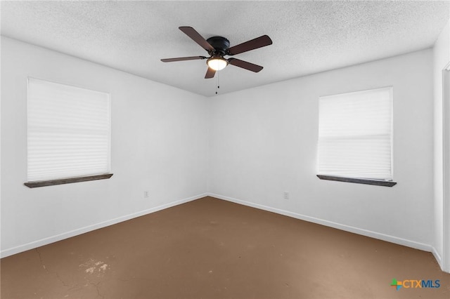 spare room with ceiling fan, concrete flooring, and a textured ceiling