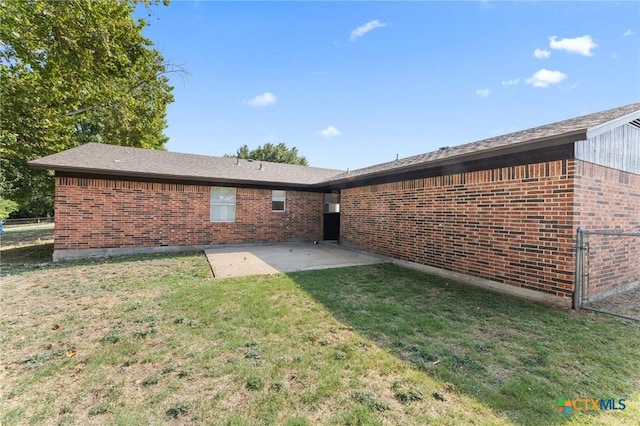 rear view of house featuring a patio area and a lawn