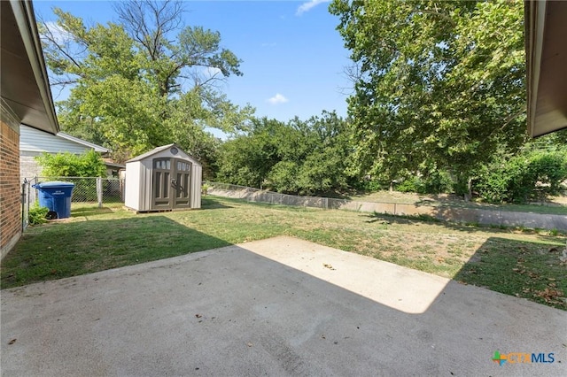 view of yard featuring a shed and a patio area